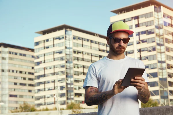 Hombre con tableta contra edificios de la ciudad —  Fotos de Stock