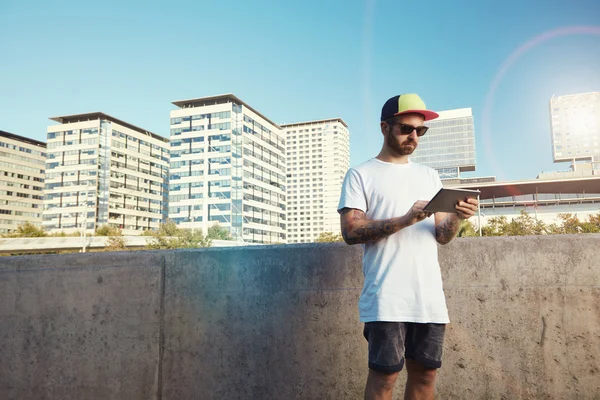 Joven tatuado con tableta en la ciudad — Foto de Stock