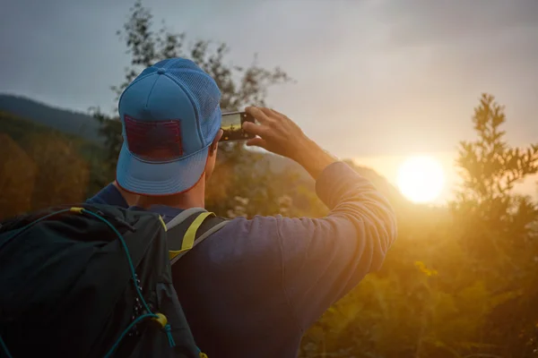 Backpacker scattare foto del tramonto su smartphone — Foto Stock