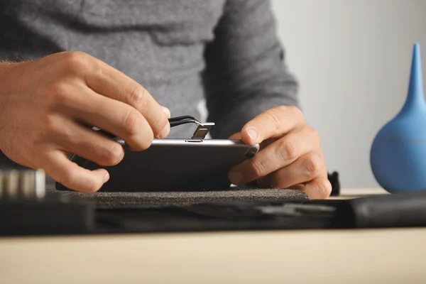 Master uses pincher tool to remove sim card — Stock Photo, Image