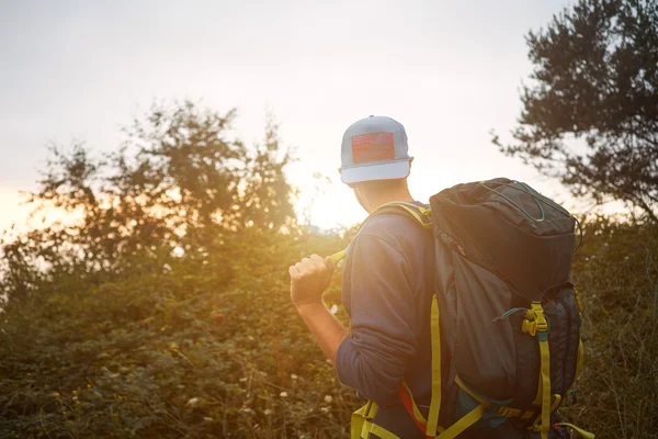 Trekker a piedi sulla collina tra gli alberi — Foto Stock