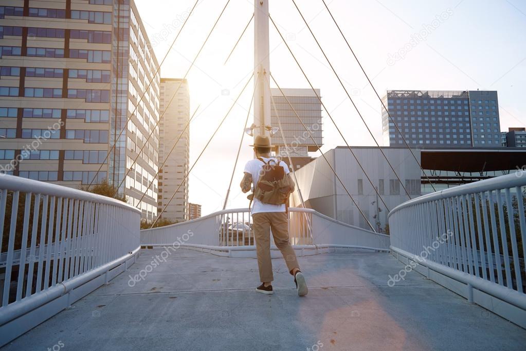 traveler walks away on city bridge