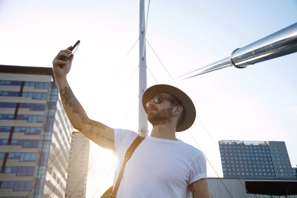 Hombre tomando selfie en puente de la ciudad — Foto de Stock