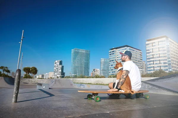 Surfař sedí na longboard a objímání psa — Stock fotografie