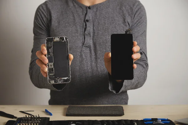 Майстер показує корпус смартфона і новий екран заміни — стокове фото
