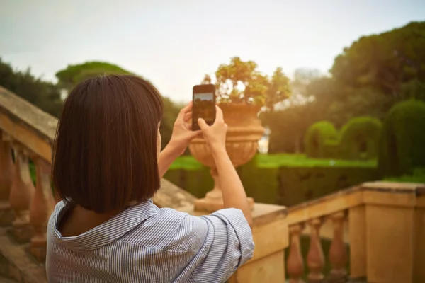 Menina tirando uma foto no parque no smartphone — Fotografia de Stock