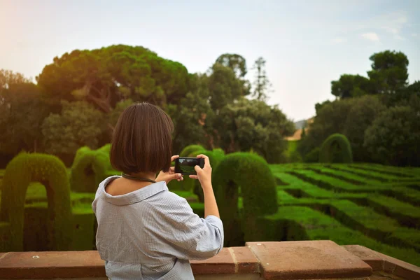 Girl taking a photo in  park on smartphone — Stock Photo, Image