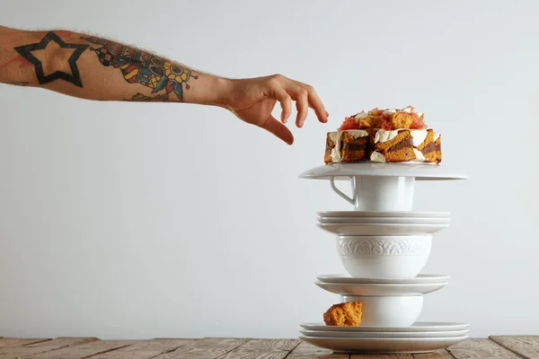 Hand reaching for piece of cake — Stock Photo, Image