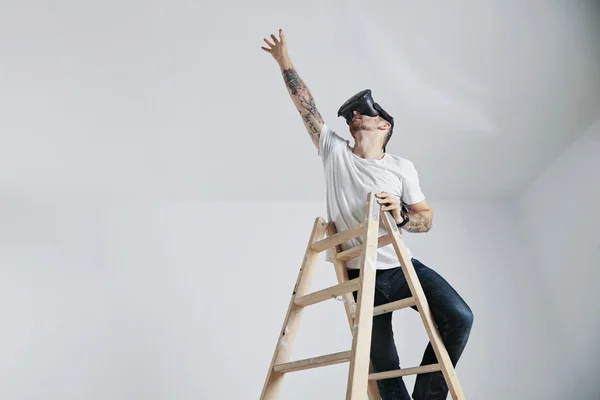 Man in de Vr-bril staande op een ladder — Stockfoto