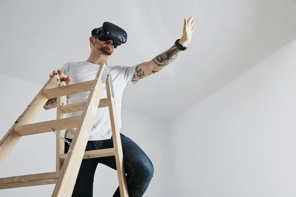 Hombre joven en gafas VR en la parte superior de la escalera de madera — Foto de Stock