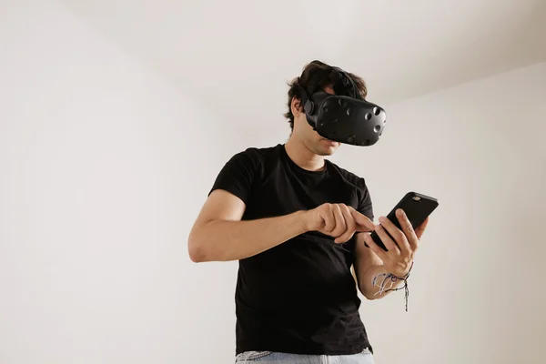 Hombre en gafas VR mirando el teléfono inteligente — Foto de Stock