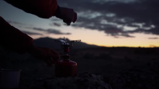 Uomo riscaldare l'acqua sul fornello a gas campeggio di notte — Video Stock