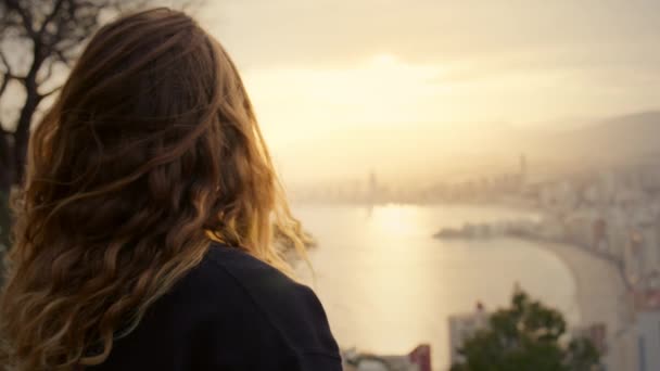 Mujer reloj puesta de sol sobre la moderna ciudad de gran altura — Vídeos de Stock
