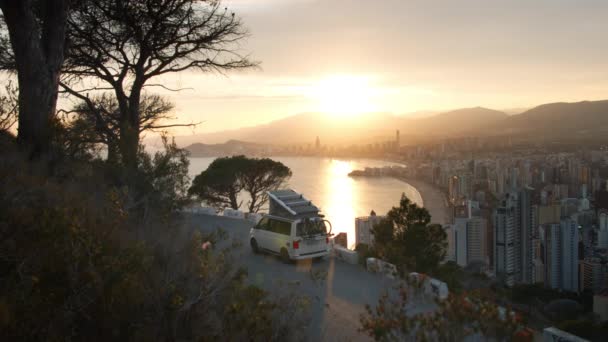 Camping RV van caravan parked at sunset over city — Stock Video