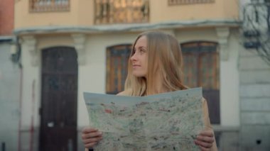 Eski Avrupa kasabasında şehir haritası olan genç bir kadın