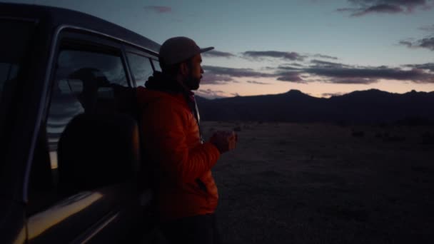 Mężczyzna na wycieczce pije o zachodzie słońca w pobliżu vana — Wideo stockowe