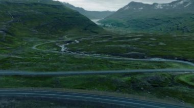 İzlanda fiyordundaki destansı viraj yolunun insansız hava aracı çekimi.