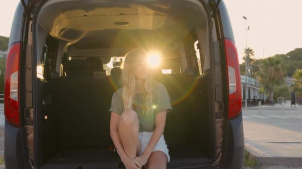 Donna guardare il tramonto dal bagagliaio posteriore della macchina — Video Stock