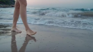 Plajda çıplak ayakla yürüyen bir kadın, tropik bir cennet.