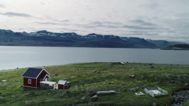 Klein rood huis op fjord landschap in Scandinavië — Stockvideo