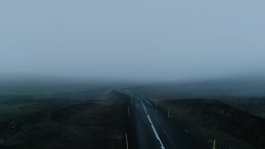 İzlanda 'daki dağda hüzünlü sisli bir yol