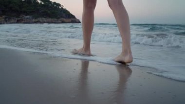Plajda çıplak ayakla yürüyen bir kadın, tropik bir cennet.