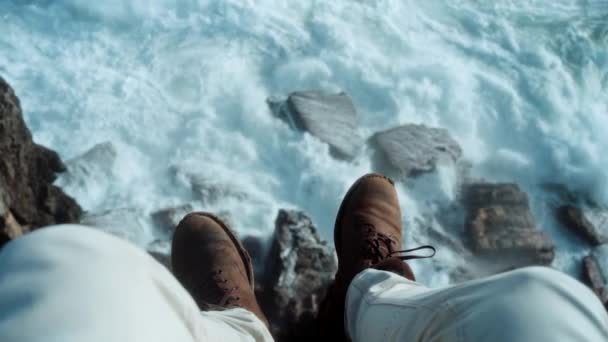 Cinematic avontuur zoeker op klif over golven — Stockvideo