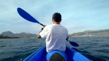 Açık denizde mavi kanolu bir adamın dikiz görüntüsü