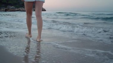 Plajda çıplak ayakla yürüyen bir kadın, tropik bir cennet.