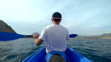 Açık denizde mavi kanolu bir adamın dikiz görüntüsü