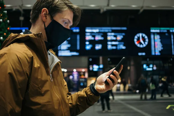 Чоловік в масці для обличчя чекає на вокзал або аеропорт — стокове фото