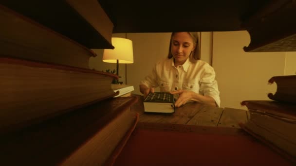 Vergrößern Frau holt Buch aus dem Regal und studiert — Stockvideo