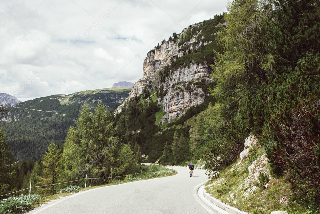 Professional road cyclist on training trip in alps