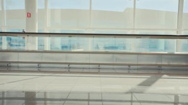 İki arkadaş boş havaalanı terminalinde şakalaşıyor.