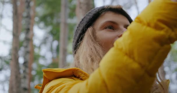 Mujer joven en el bosque hacer fotos o señal de búsqueda — Vídeos de Stock