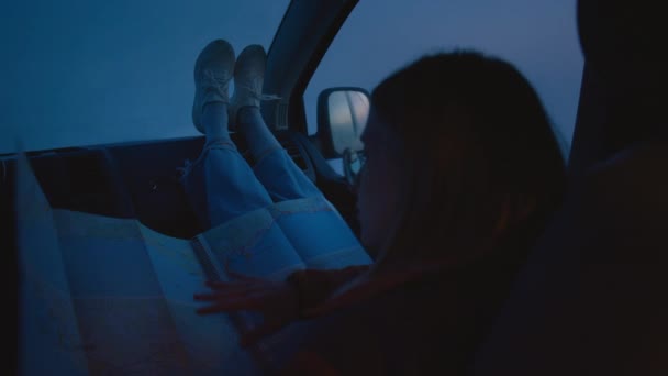 Moody kvinna i mörker titta på färdplan i bilen — Stockvideo