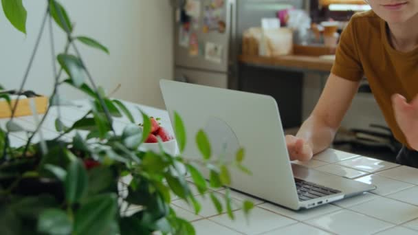 Mujer joven trabaja en casa oficina cocina en el ordenador portátil — Vídeos de Stock