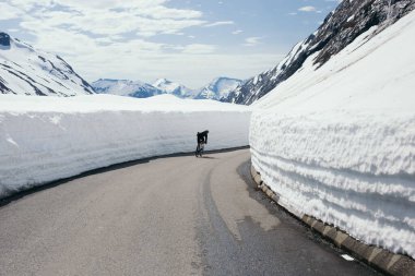 Kışın dağ yolunda motosikletçi. 