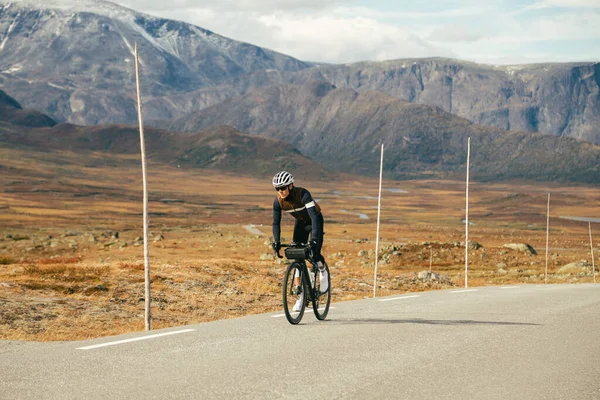 Ciclista profissional de estrada de montanha em artes de inverno — Fotografia de Stock