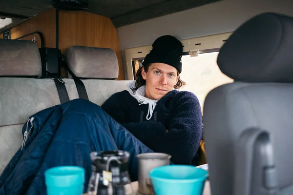 Junger Mann sitzt gemütlich warm im Wohnmobil — Stockfoto