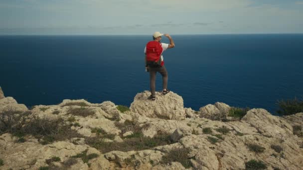 Uomo con zaino escursione sul crinale della falesia montana — Video Stock