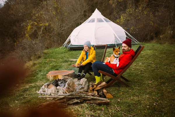 Couple sit near camping campfire and glamping tent — Stock Photo, Image