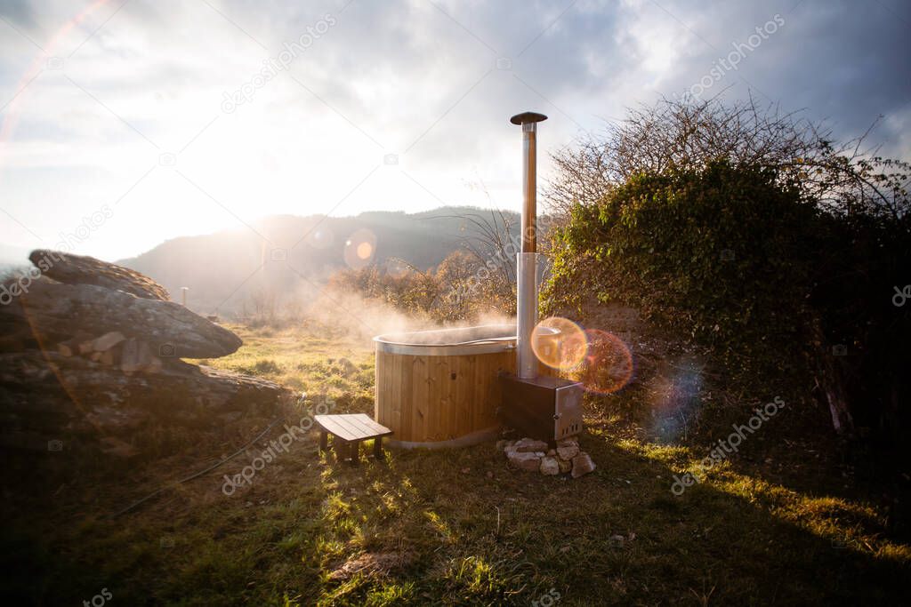Steaming wooden hot tub in middle of field nature