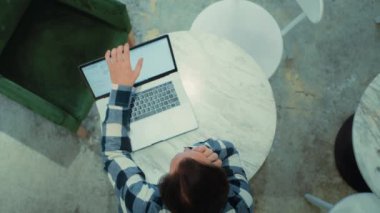 Yorgun adam dizüstü bilgisayar masasında uzandı. 