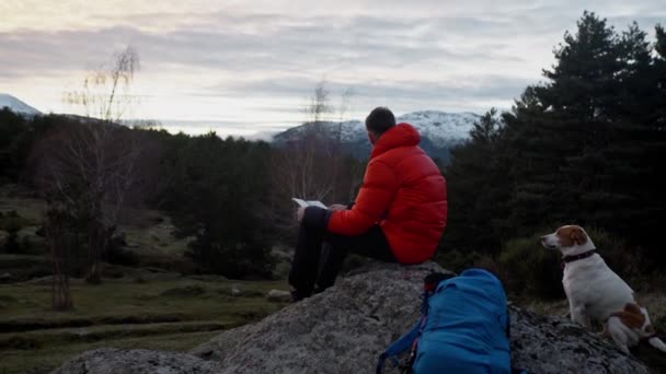 Joven en caminata navega mapa de papel en los bosques — Vídeo de stock