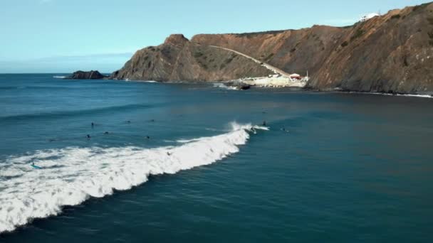 Aerial of surfers ride long wave in portugal — Vídeo de Stock