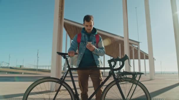 Joven viajero de moda hombre con bicicleta y teléfono — Vídeo de stock