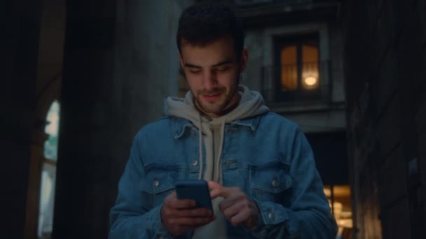 Jeune homme millénaire marcher dans la rue avec le téléphone — Video