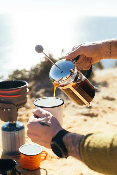 Mann brüht Kaffeespezialität in französischer Presse im Camp — Stockfoto