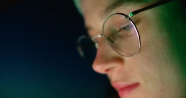 Genç bir kadın gece telefondaki uygulamayı kontrol ediyor.